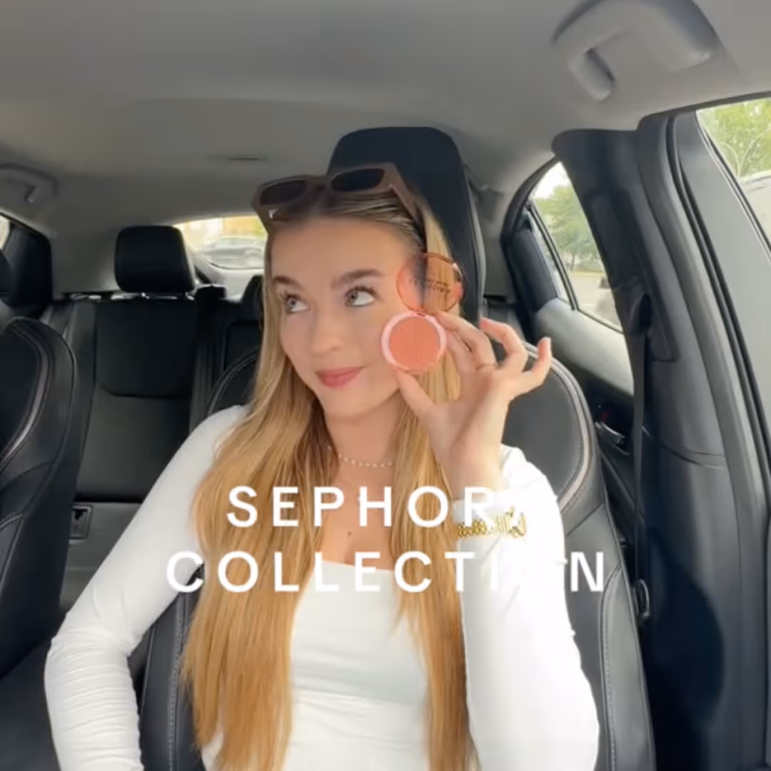 Young woman with long blonde hair sitting in a car holding up a Sephora blush compact near her face, with the text 'SEPHORA COLLECTION' overlaid.