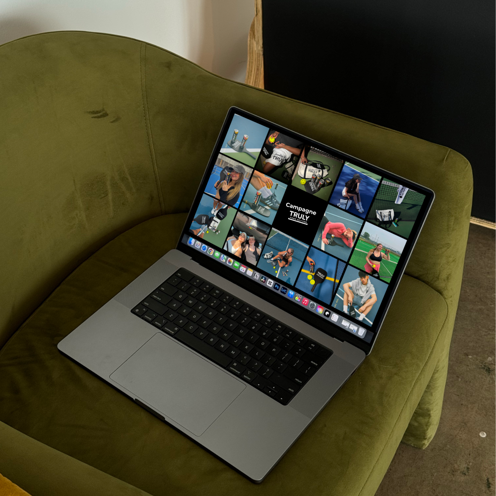 Open laptop showing a grid of images featuring people and products from the Campagne Truly pickleball brand on a green suede couch.