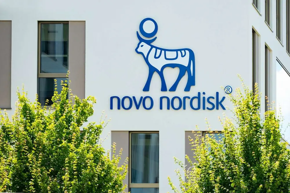 A wall with the company logo of Novo Nordisk printed on.