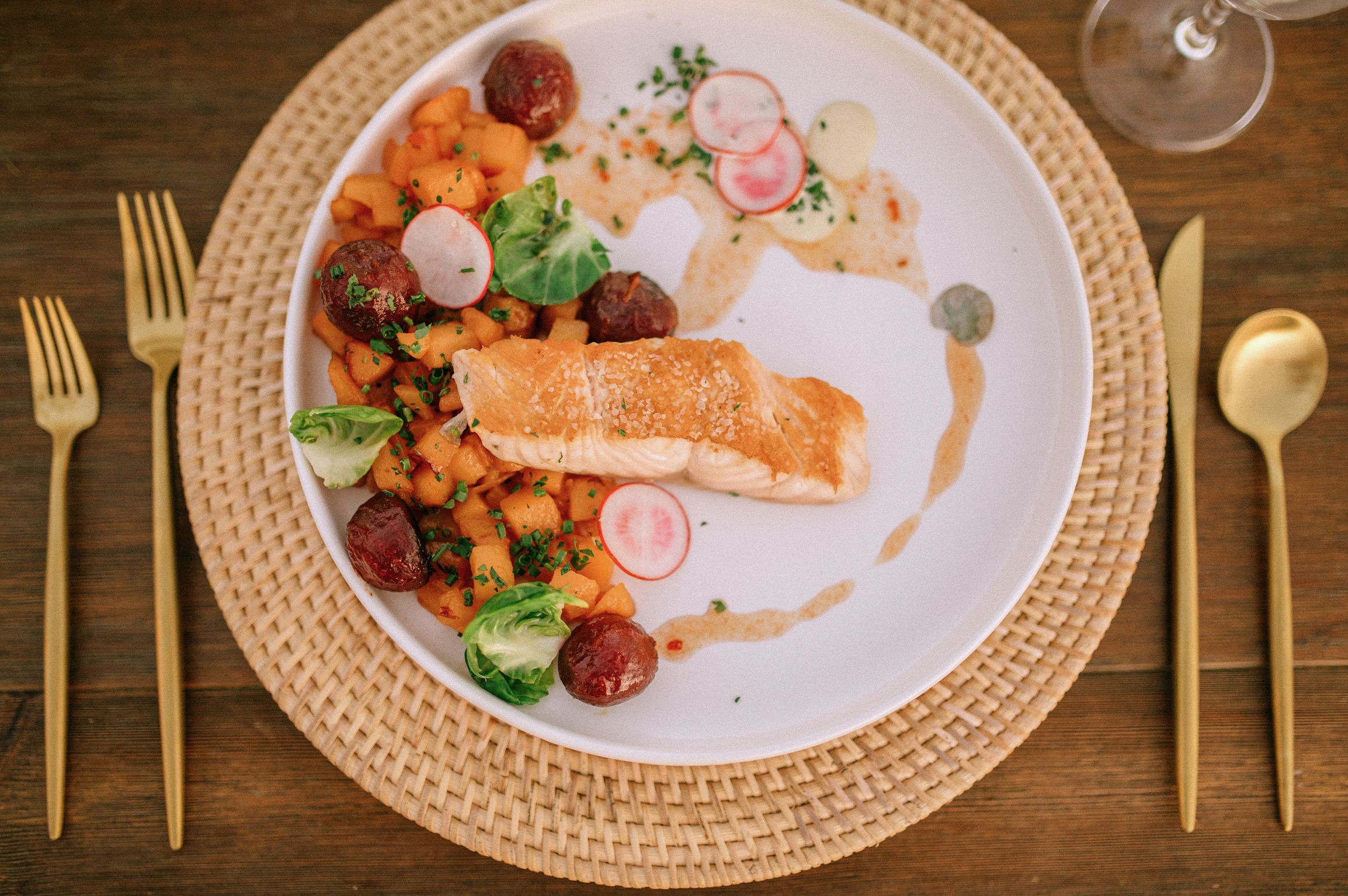 Plated salmon meal with gold cutlery by Red Sky Catering