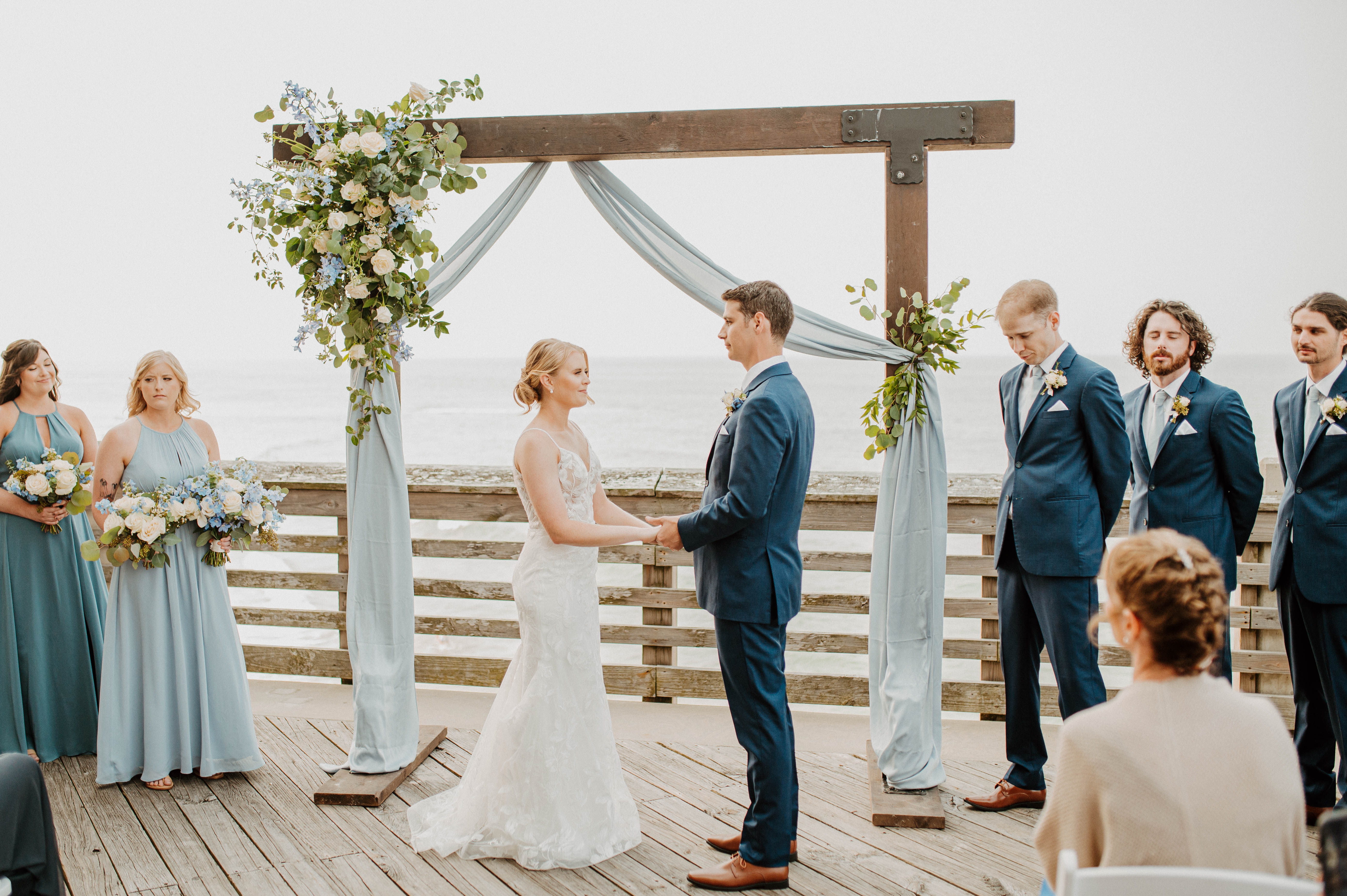 Bride and Groom at ceremony on a pier overlooking the ocean