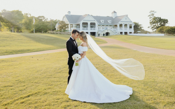 Bride and Groom on Green in front of Country Club