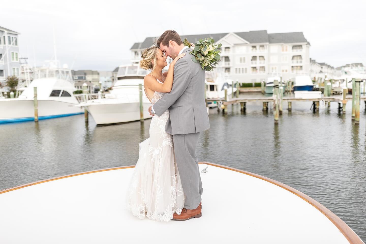 Bride and Groom on bow of boat in marina