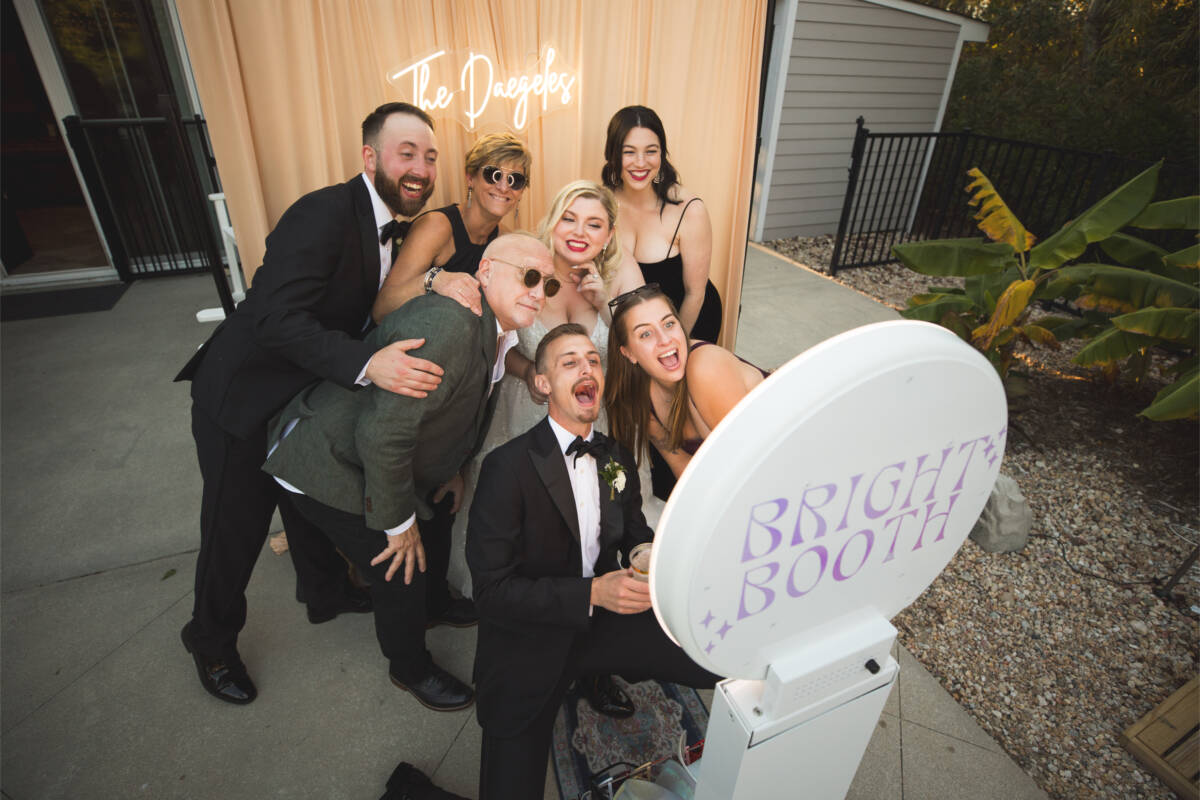 Wedding guests pose in front of open air photo booth at an Outer Banks wedding