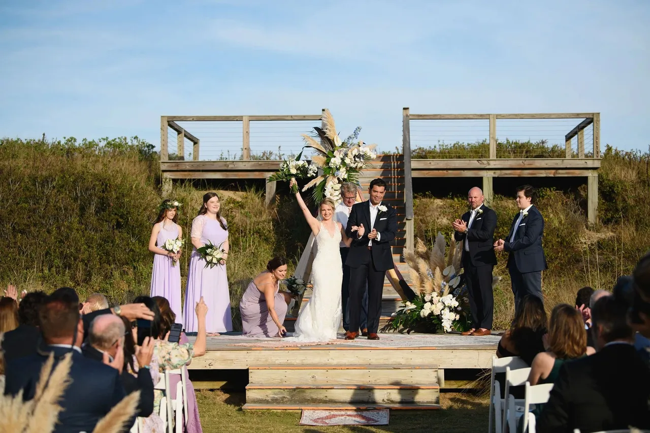 Bride and groom celebrate at their ceremony officiated by Scott Hamblen on the Outer Banks