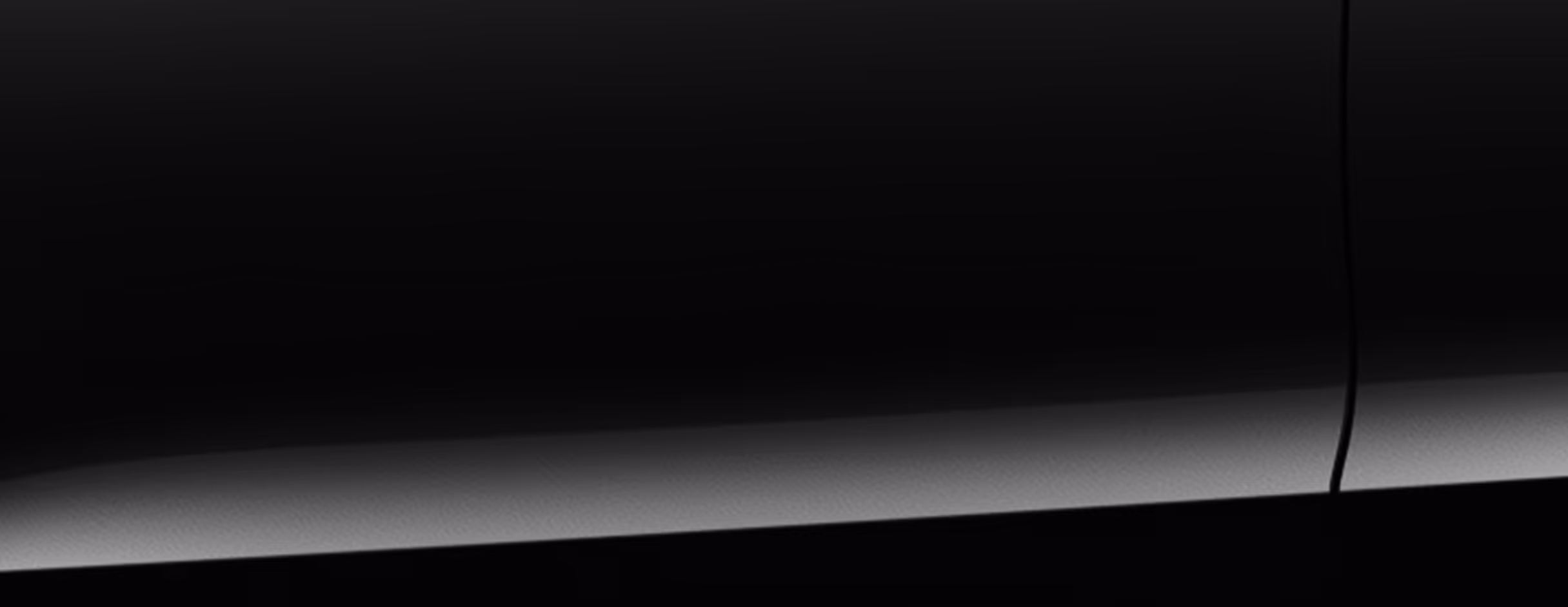 Eine minimalistische Detailaufnahme zeigt einen Ausschnitt der Karosserie des Škoda Kamiq Balance in der Lackierung Black-Magic Perleffekt. 
