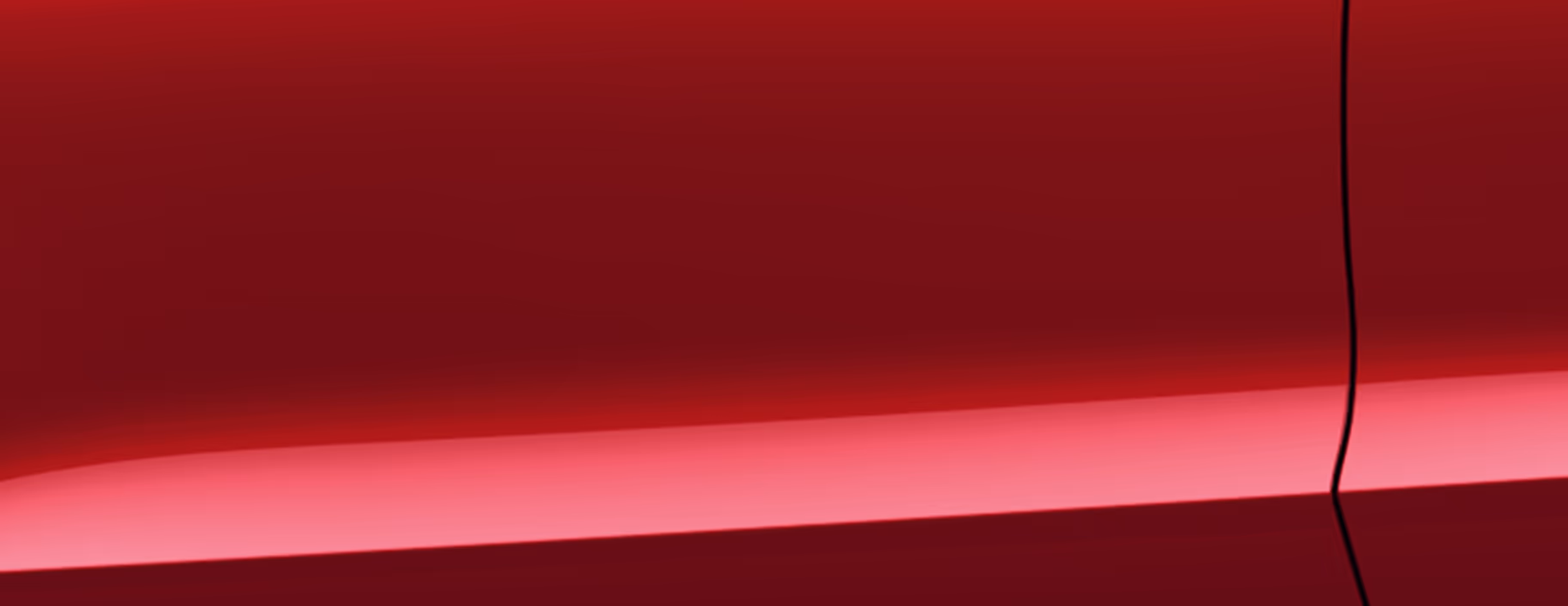 Eine minimalistische Detailaufnahme zeigt einen Ausschnitt der Karosserie des Škoda Kamiq Balance in der Lackierung Velvet-Rot Metallic. 
