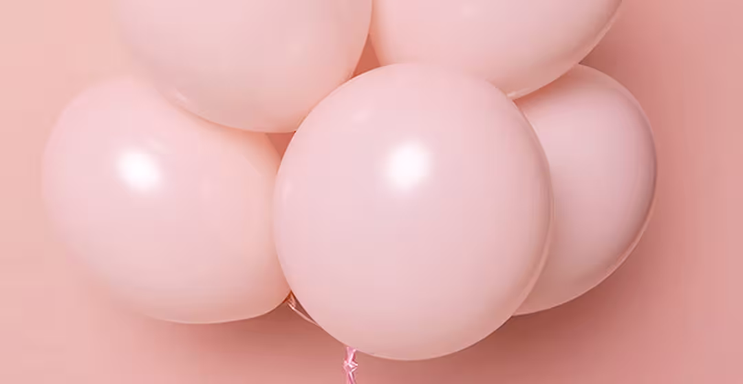 Cluster of pale pink balloons against a matching pink background.