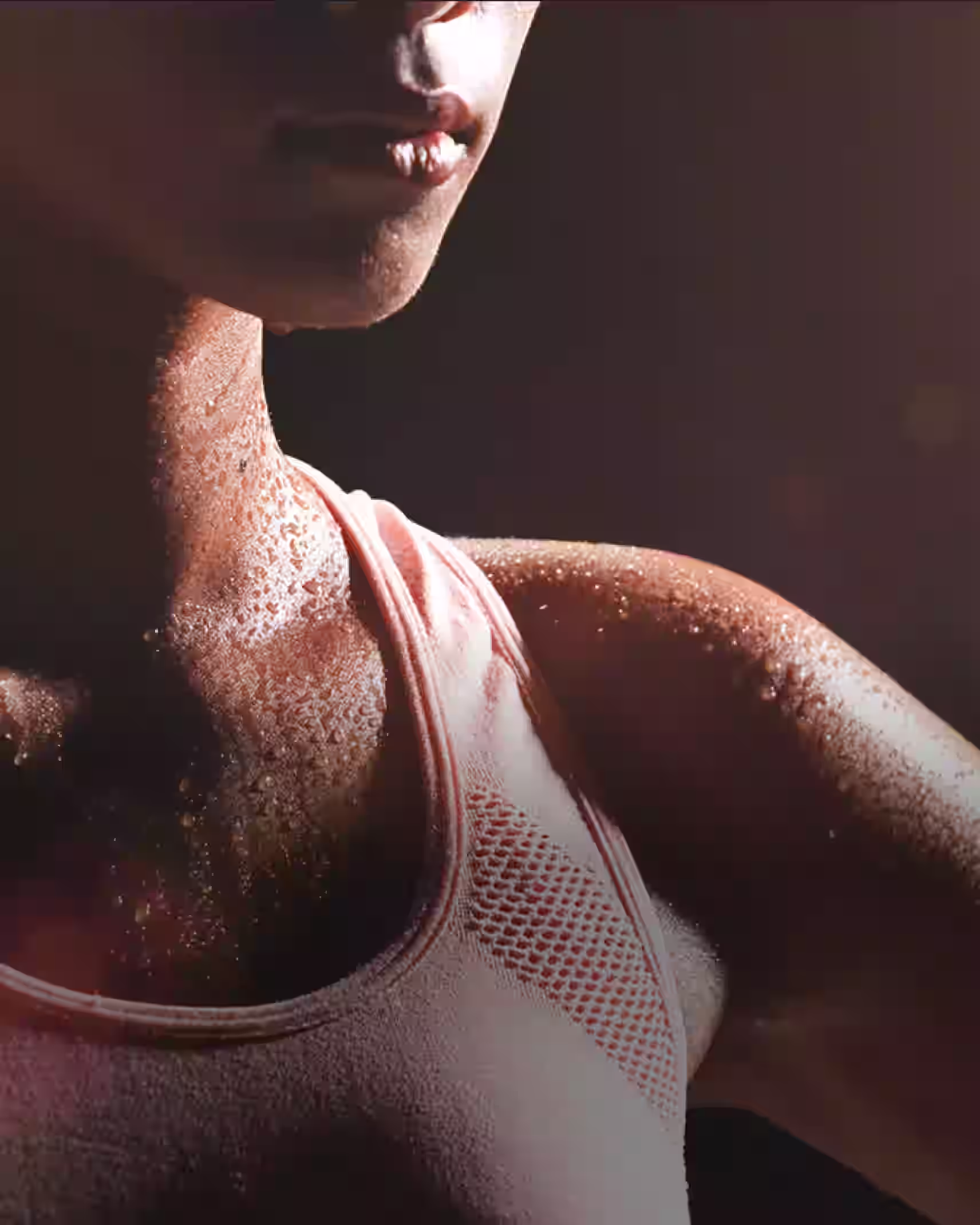 Close-up of a sweaty person in a pink sports tank top during a workout.