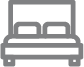 Icon of a bed with pillows and a headboard in gray.
