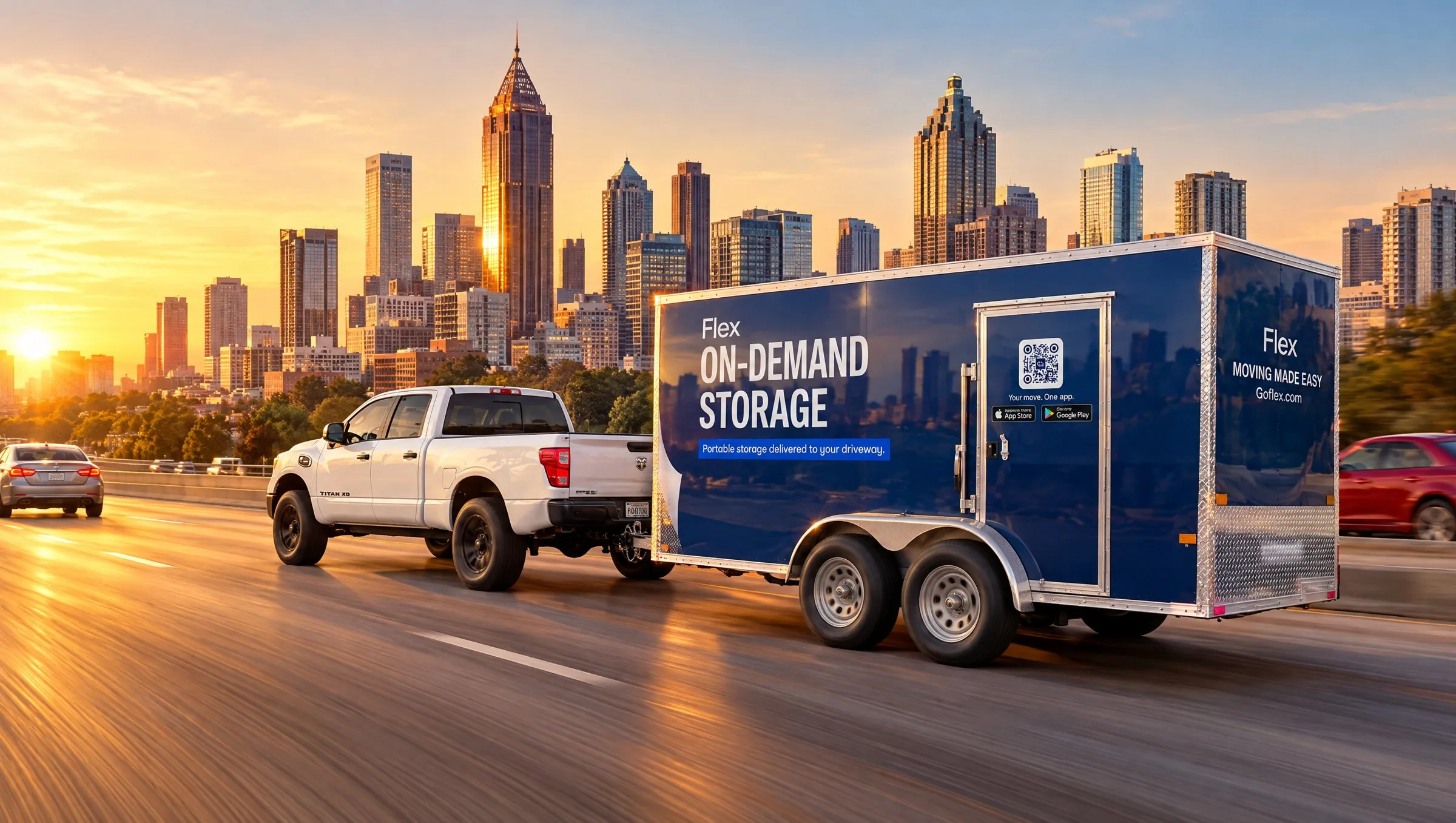 Pickup towing a Flex trailer on the highway with the Atlanta skyline at sunset
