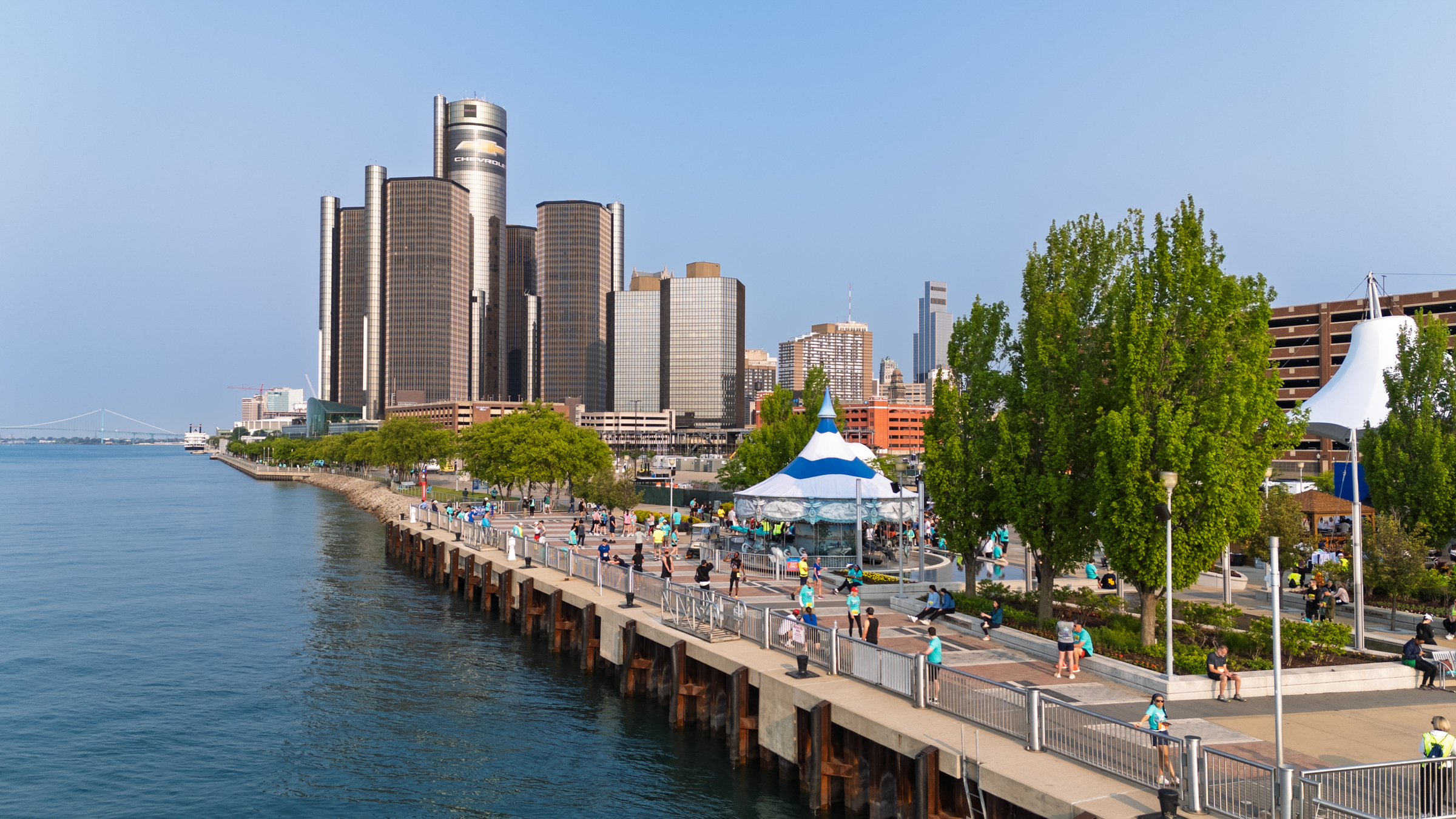 Exterior photo of the Detroit riverfront, facing east to west, featuring the Renaissance Center in the background.