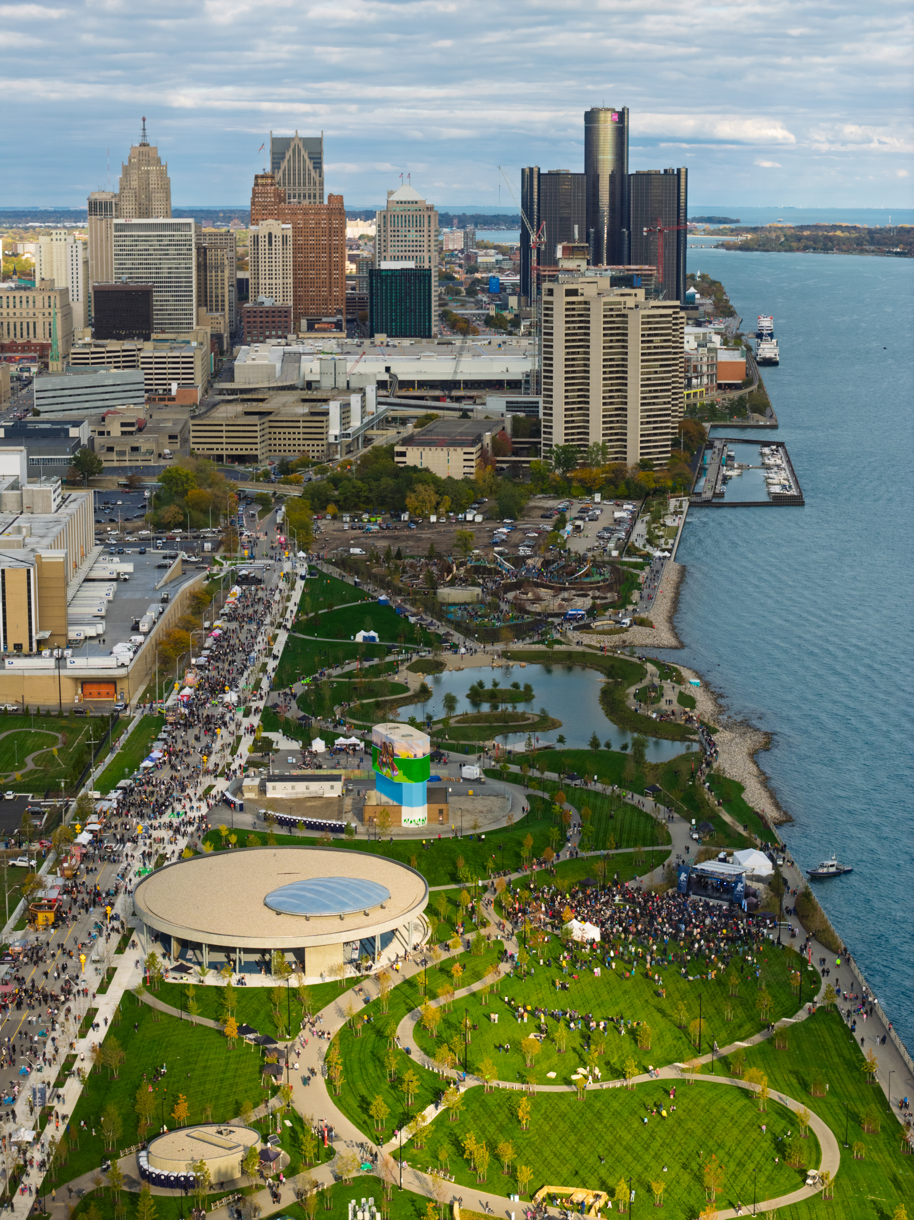 Aerial photo of the Detroit riverfront, facing west to east with various public spaces, featuring Ralph C. Wilson park.