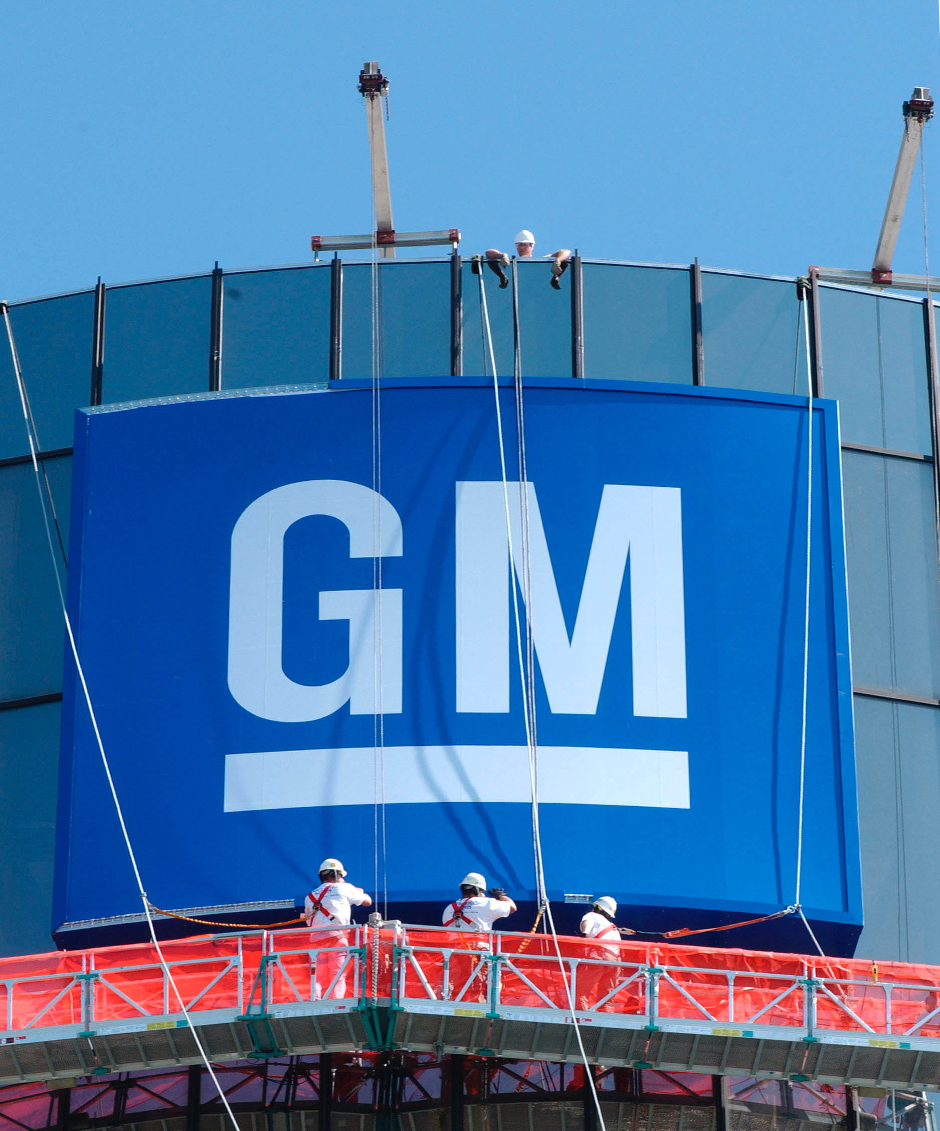 Historical photo of the GM banner being applied to the exterior of the Renaissance Center.