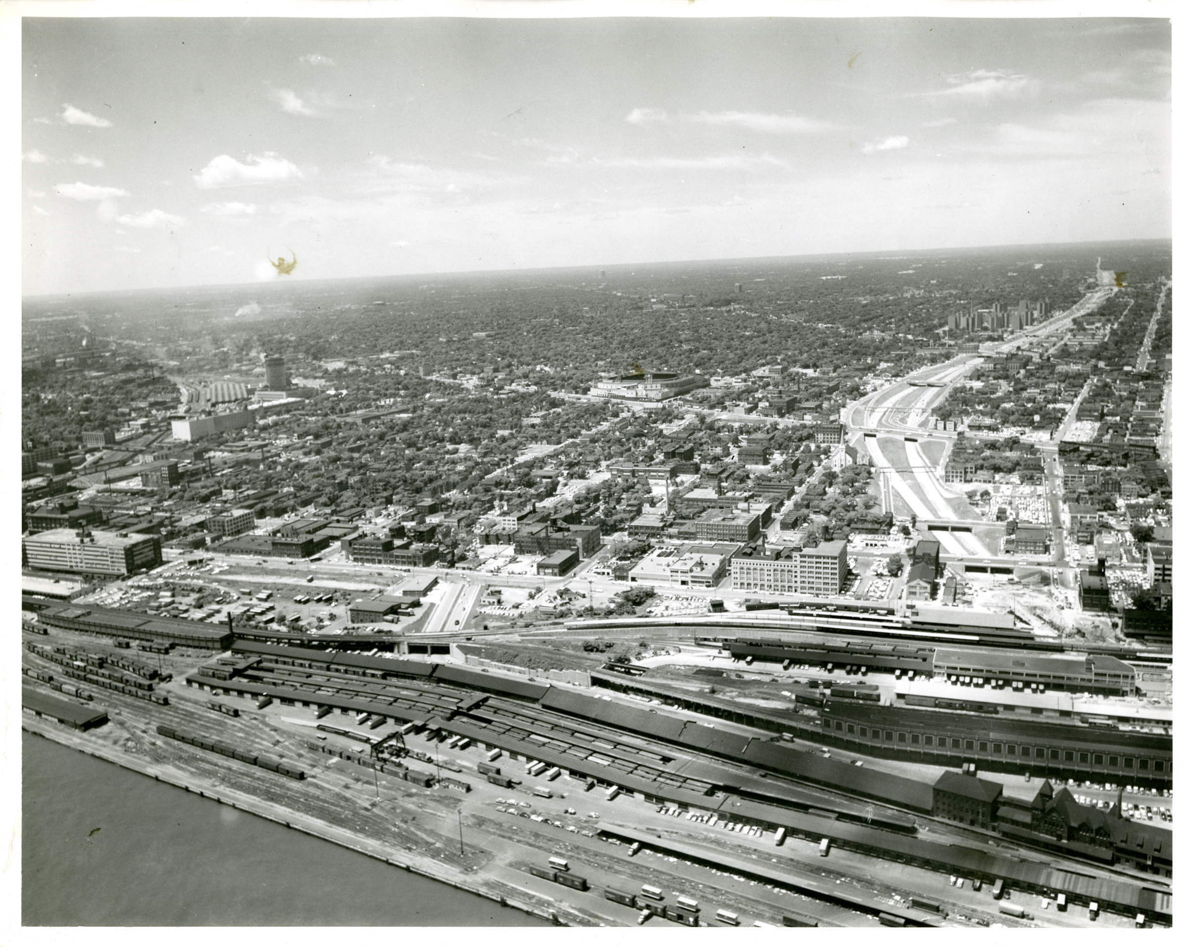 Historical photo of the downtown riverfront area as a "patchwork" of industry, parking lots, and roadways.