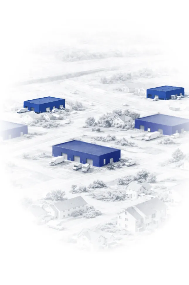 Aerial view of an industrial area with multiple blue warehouse buildings surrounded by roads and residential houses.