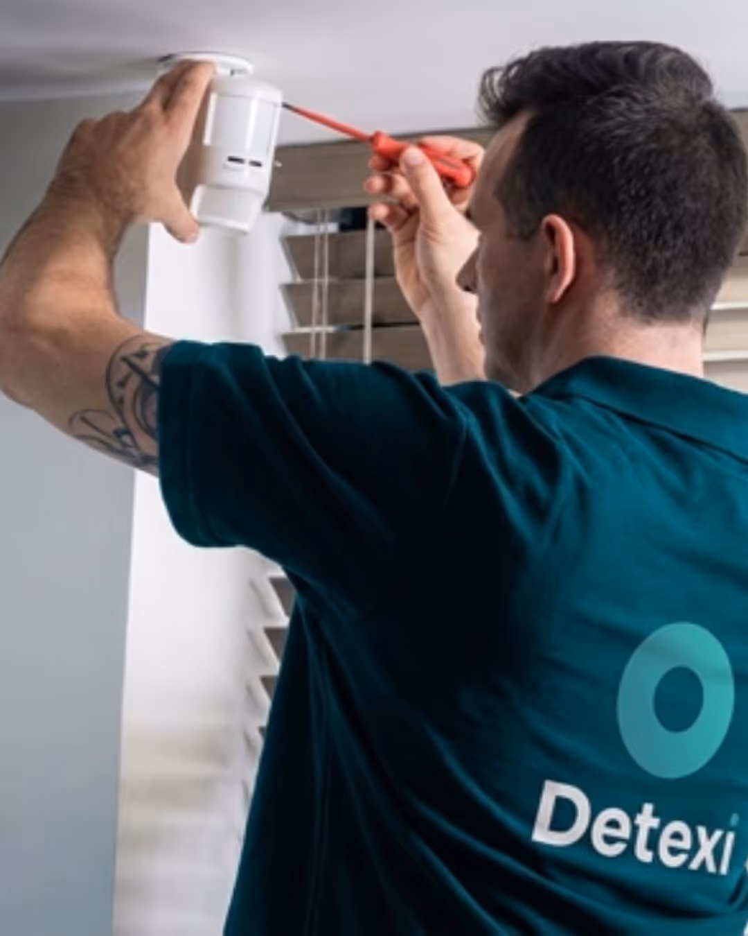 Technicien Detexi qui installe un système d'alarme
