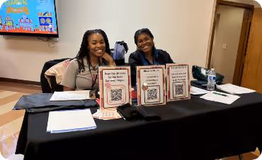 Two women sitting behind an event table