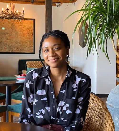 Maya Foster sitting in a chair at a table