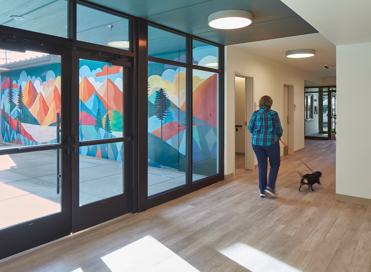 Woman Walking a dog down the hallway