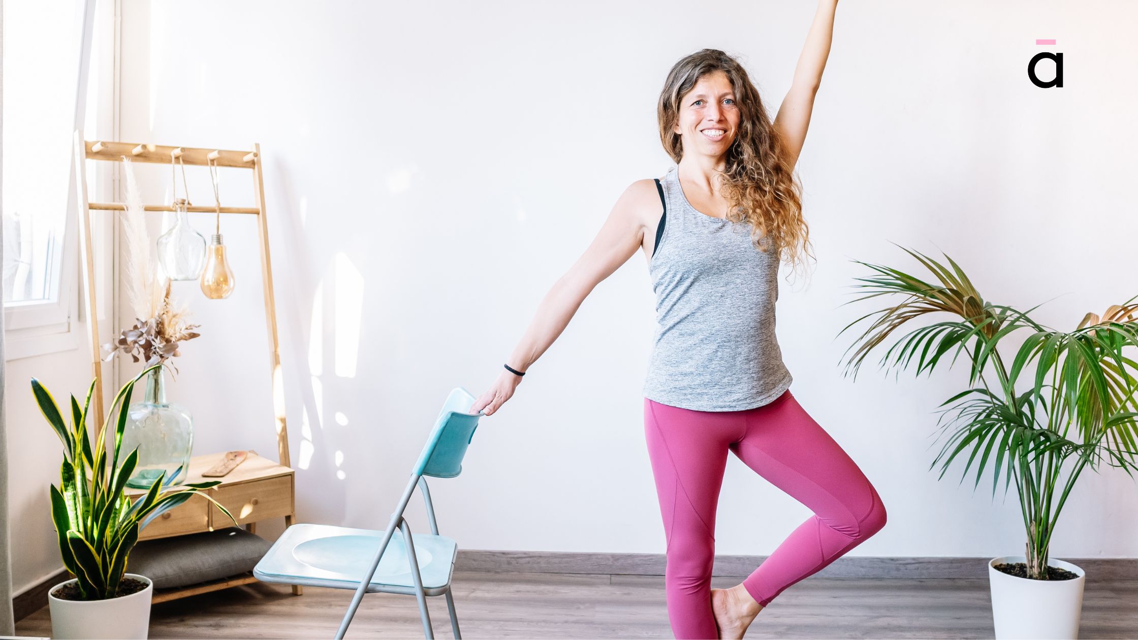 Smiling woman balancing in Tree Pose using a chair, ideal for improving stability and lower-body strength