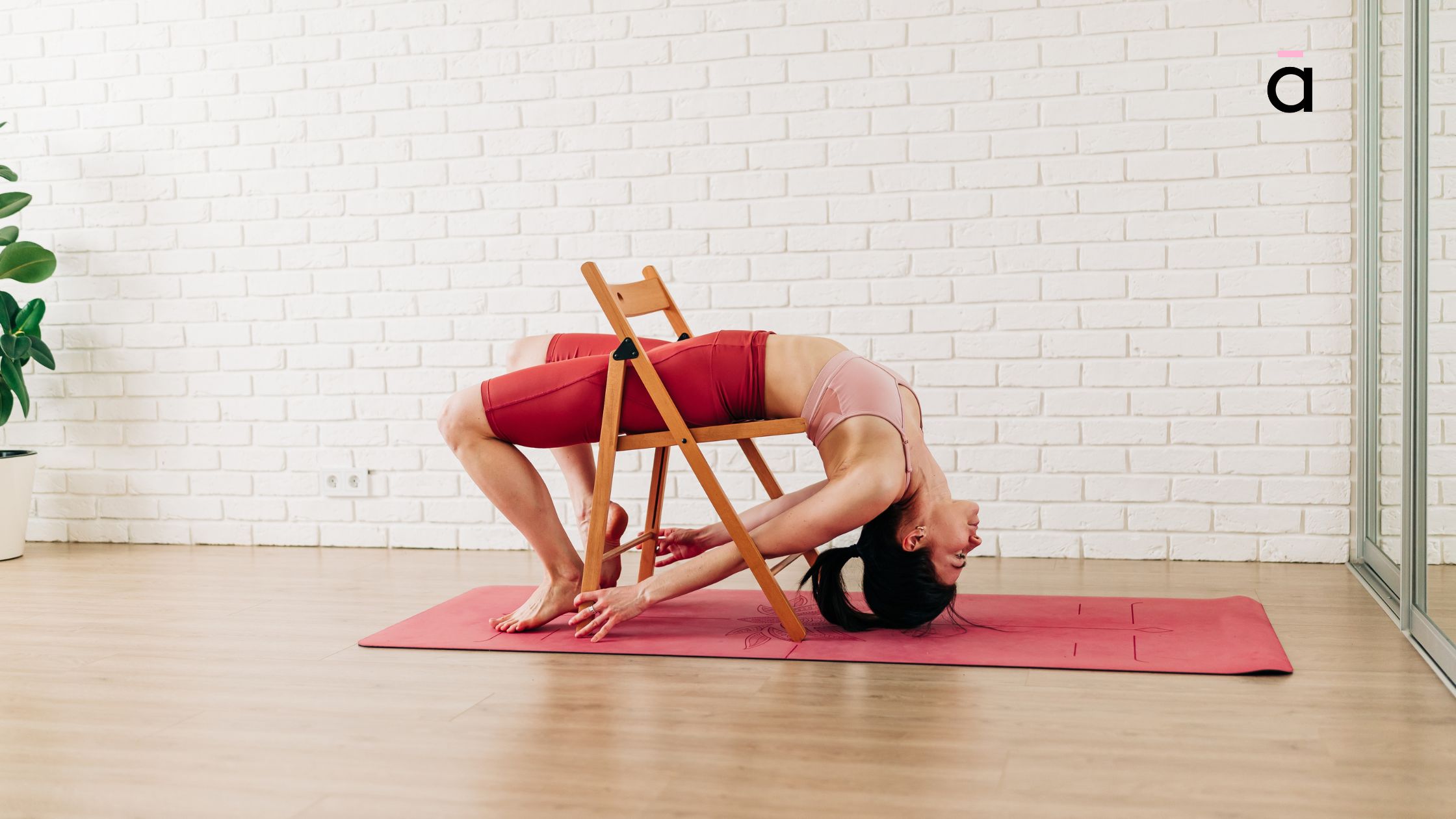 Person using a yoga chair and props to perform a safe, restorative version of Bridge Pose, opening the chest and hips