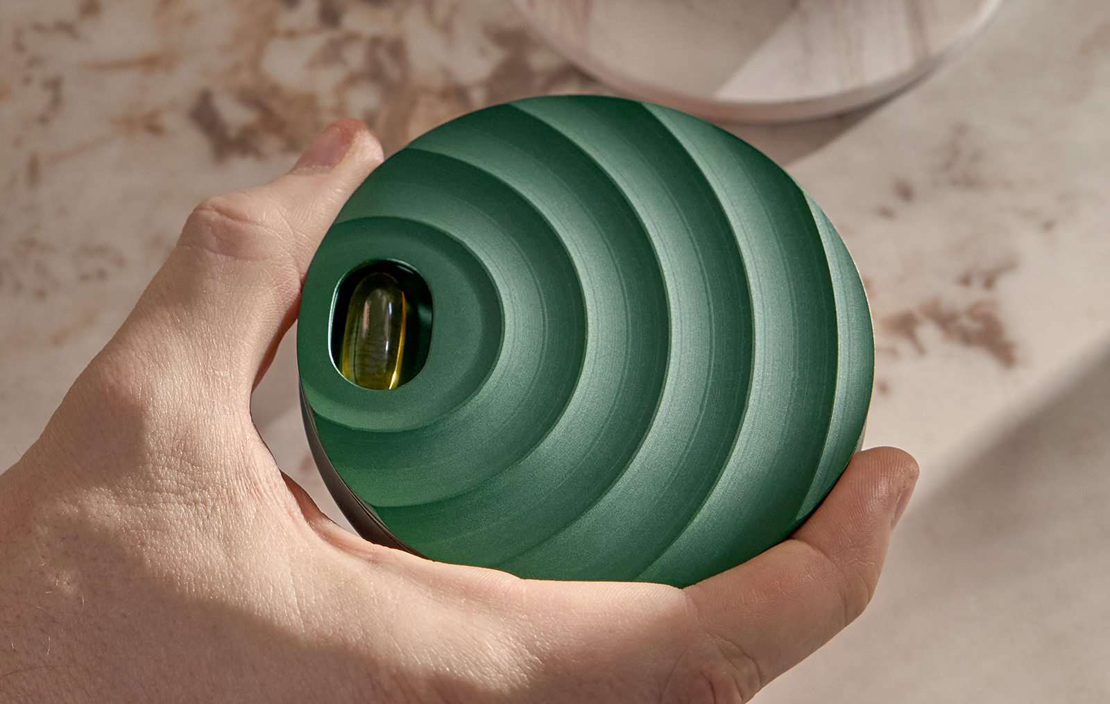 Close-up of a polished metal cylinder with circular brushed texture under studio lighting.