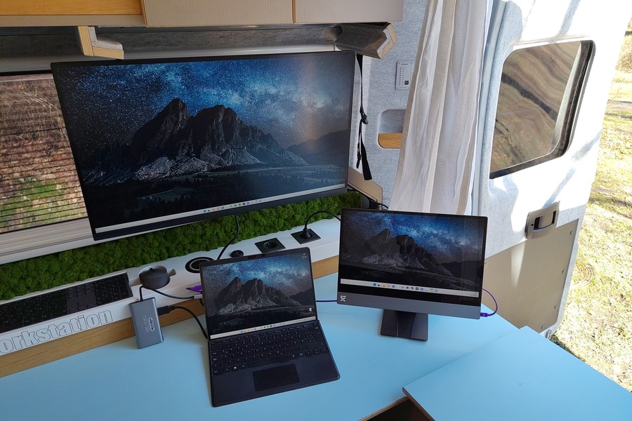 a notebook, an espresso 15" and a Dell 27" display on the desk in the back of the van