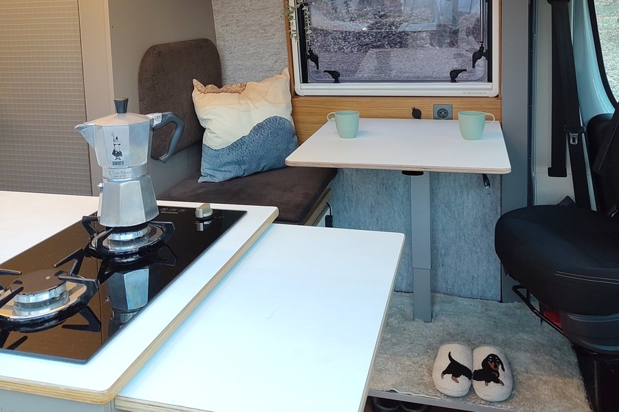 kitchen worktop in the foreground, lounge area table in the background with a pair of Dachshund slippers below the table