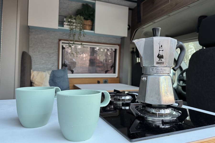 A Bialetti Moka on the Thetford gas cooker with 2 Mepal cups besides it on the kitchen worktop