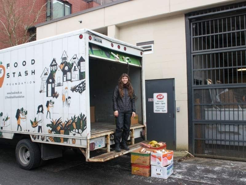 Woman standing on truck in front of donations.