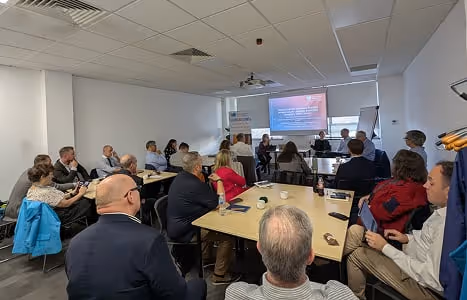 Group of people seated around tables in a conference room attending a Future Water Association working group session