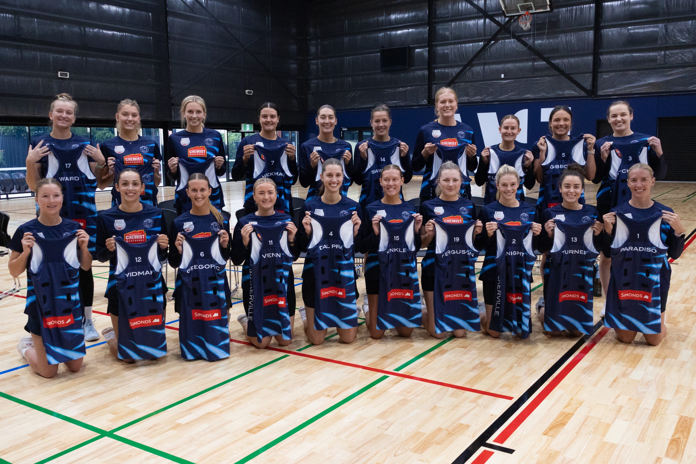 Walkerville Premier League squad holding their playing dresses at the W