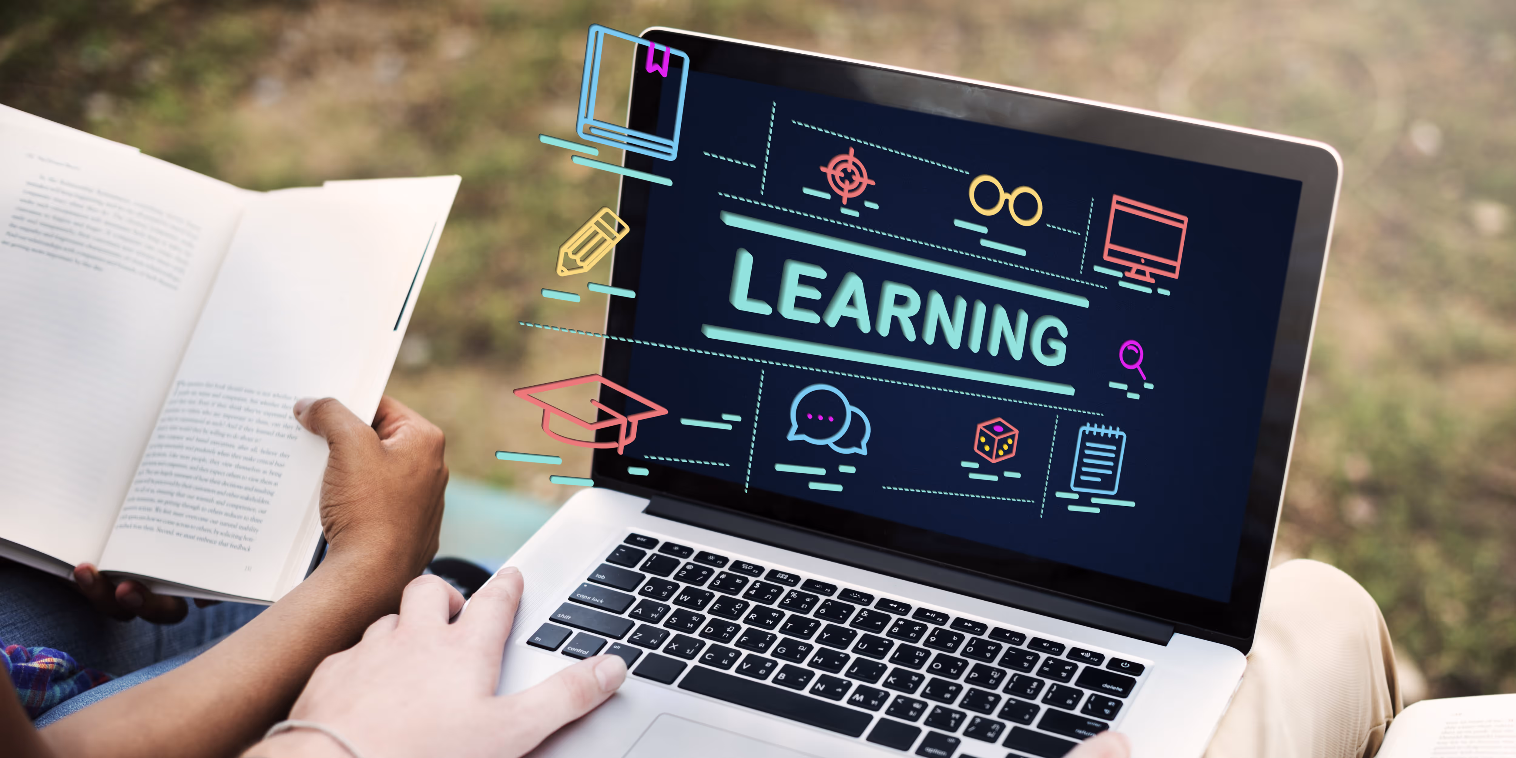 Open laptop showing colorful learning icons, person holding an open book beside it outdoors.