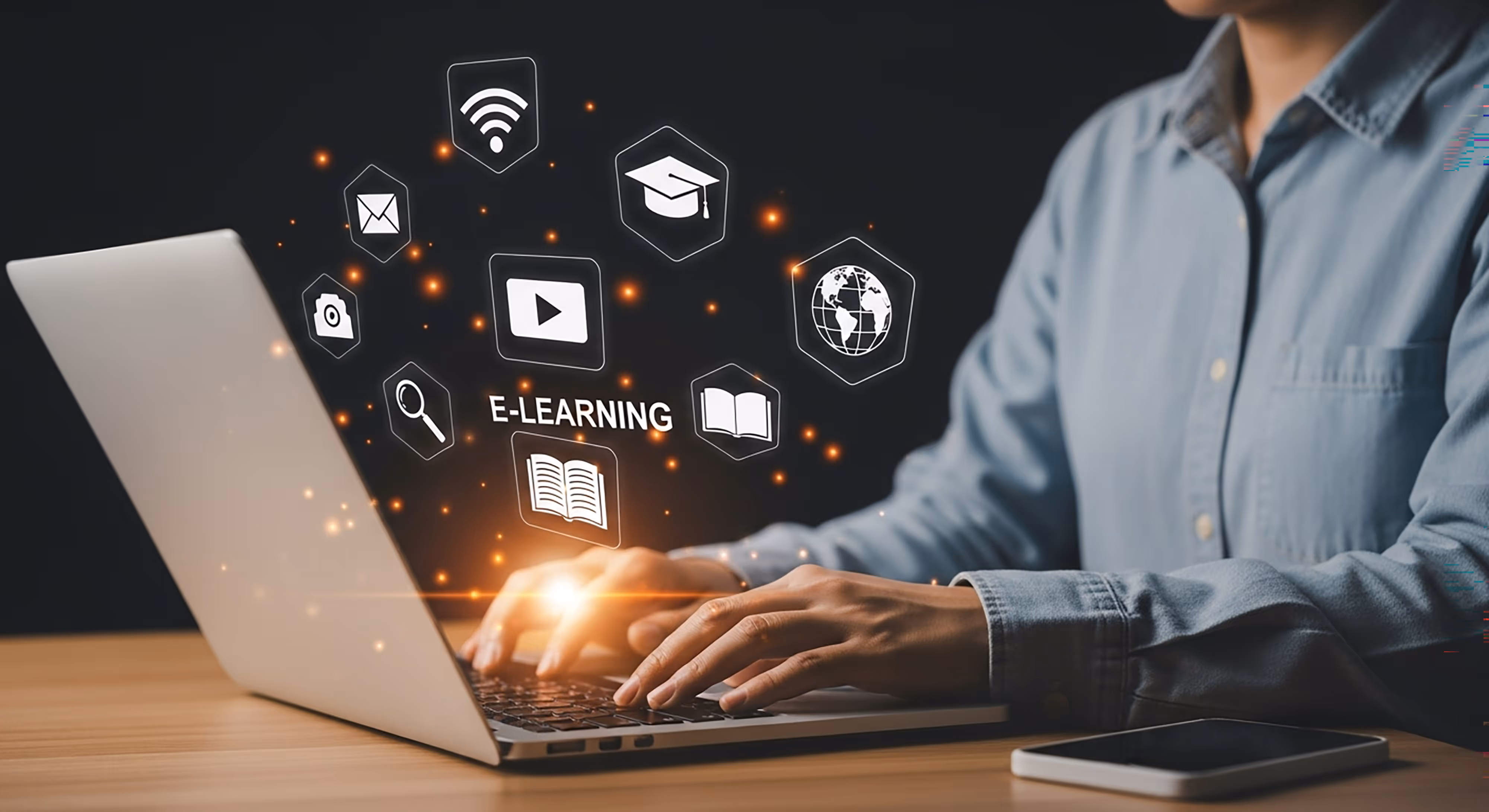 Person typing on laptop with floating digital icons and the word E-LEARNING above the keyboard.