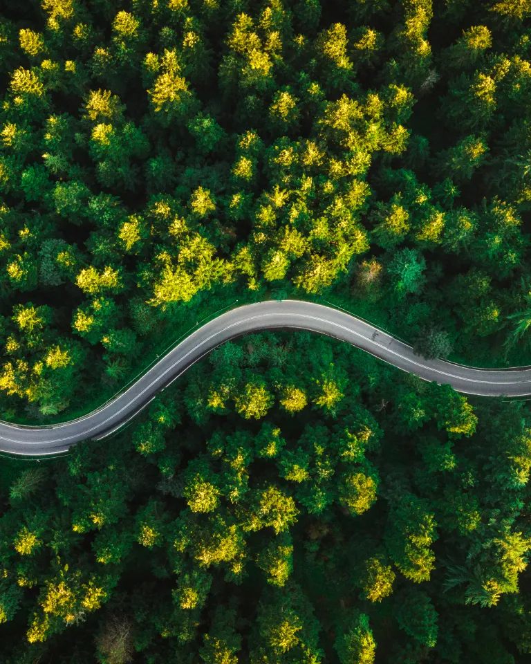 Clear glass sphere on wet sand reflecting an inverted ocean sunset with gentle waves.