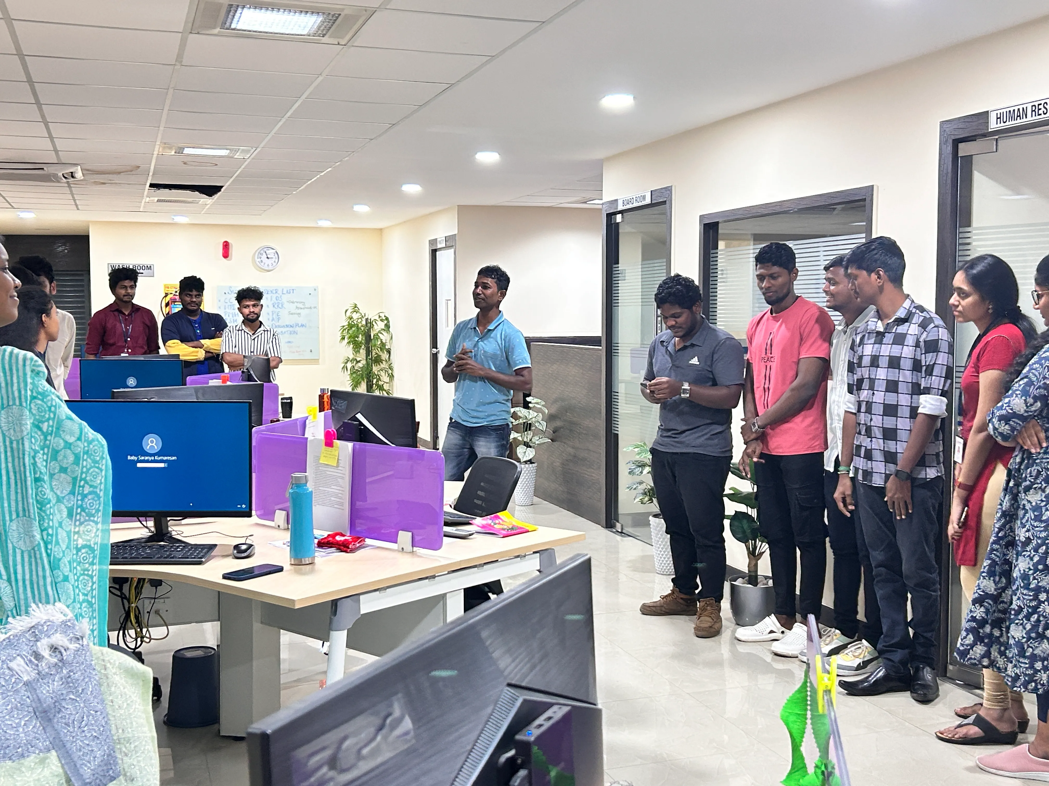 A grayscale close-up focusing on a person's hands gesturing during an office discussion.