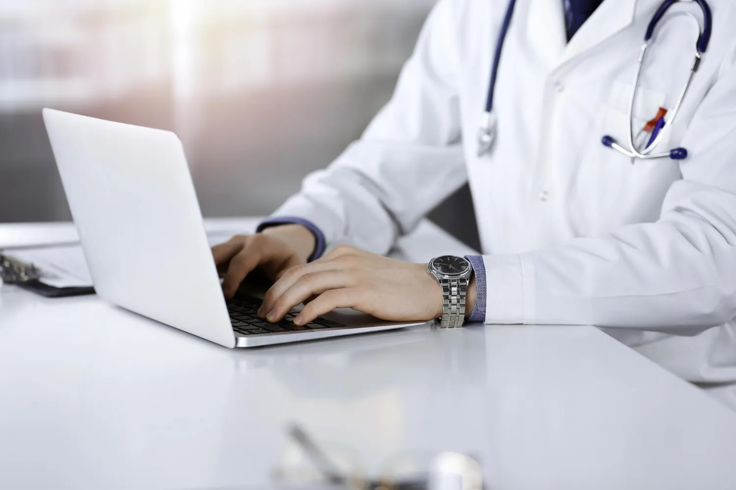 Grayscale image of a medical professional in a lab coat using a smartphone, representing medical data analysis services.
