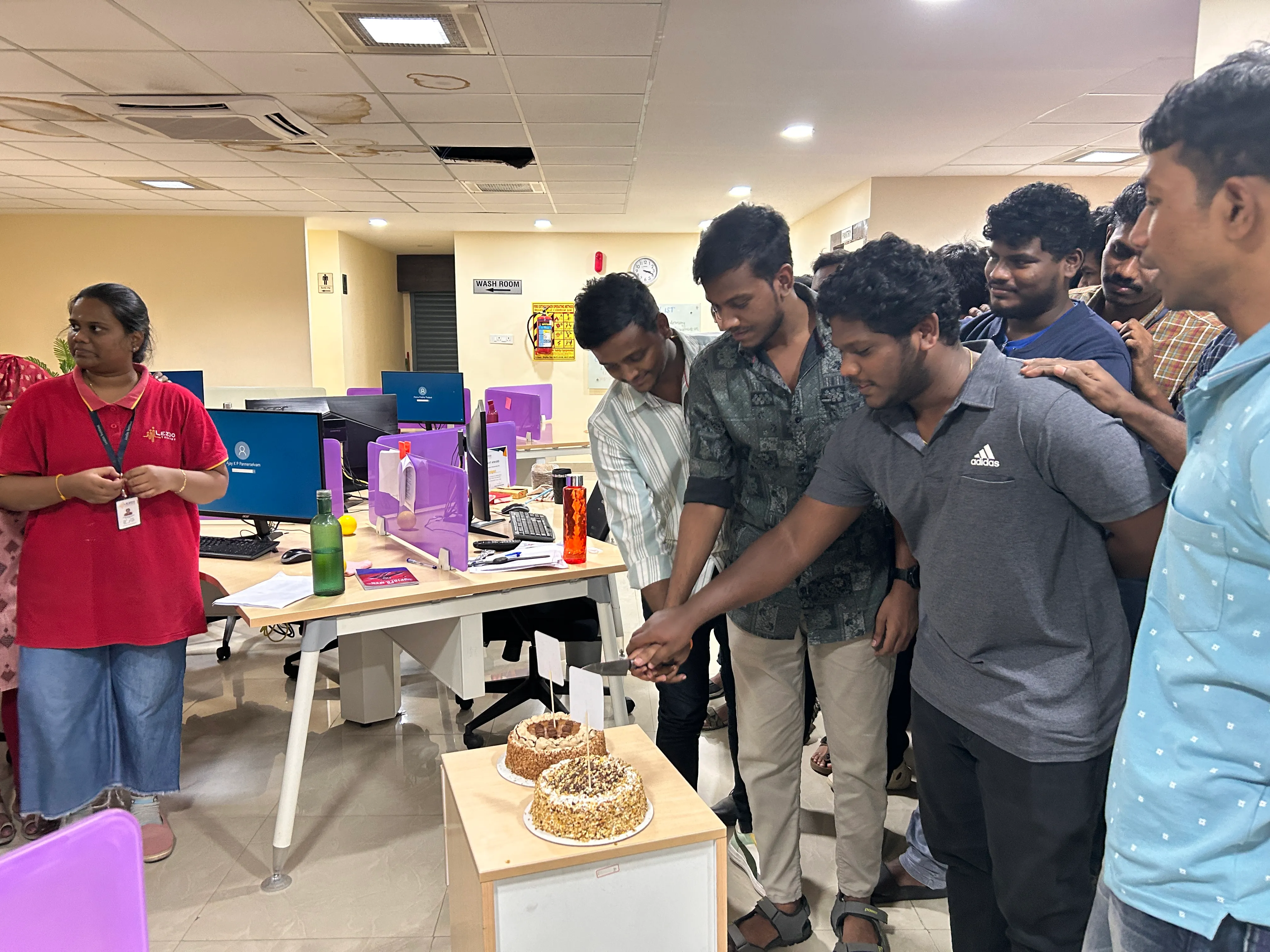 A grayscale portrait of a smiling professional woman sitting in front of a window.