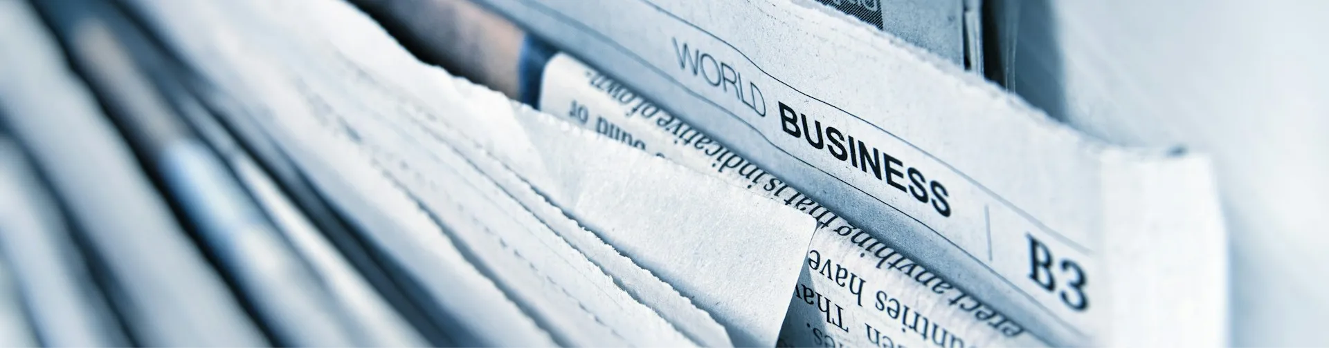Grayscale close-up image of a stack of newspapers used for a press release card.