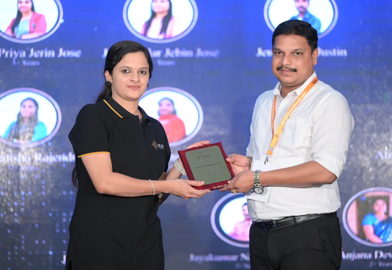 A grayscale close-up of two colleagues focused on a laptop screen during a collaborative work session.