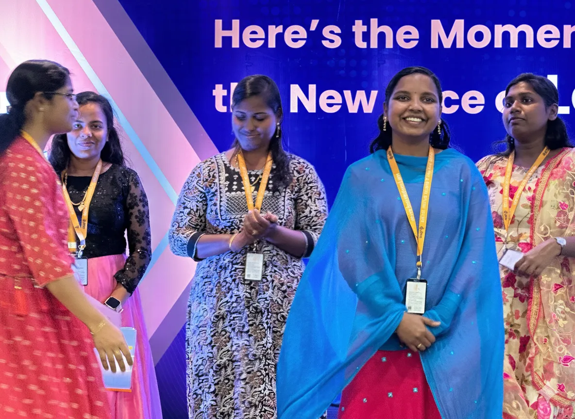 A grayscale close-up focusing on a person's hands gesturing during an office discussion.