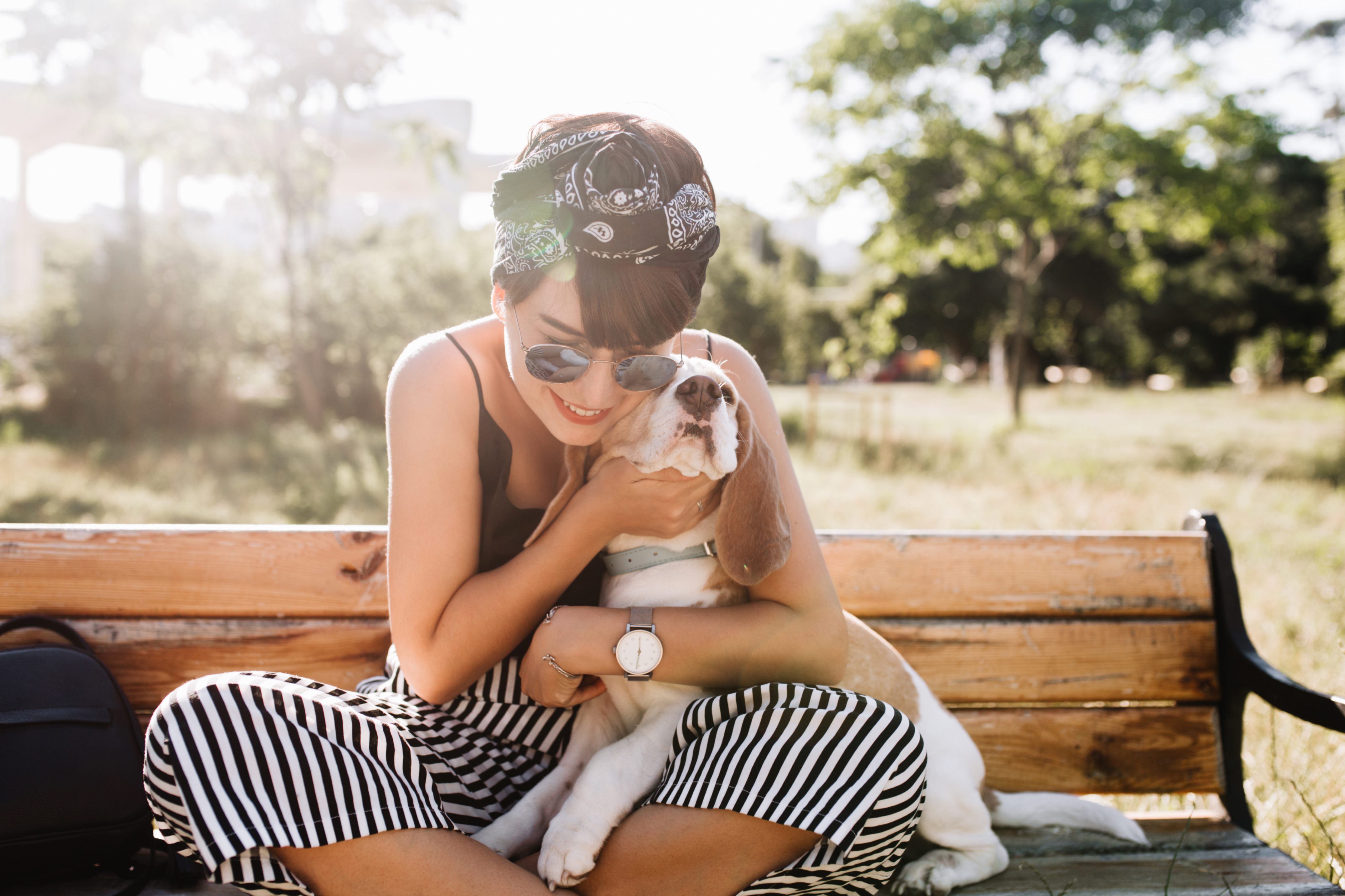 Une jeune lady fait un câlin a son basset elle porte un pantalon rayé