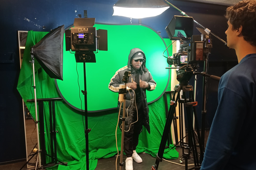 Foto van een film shoot met rapper met green screen op de achtergrond