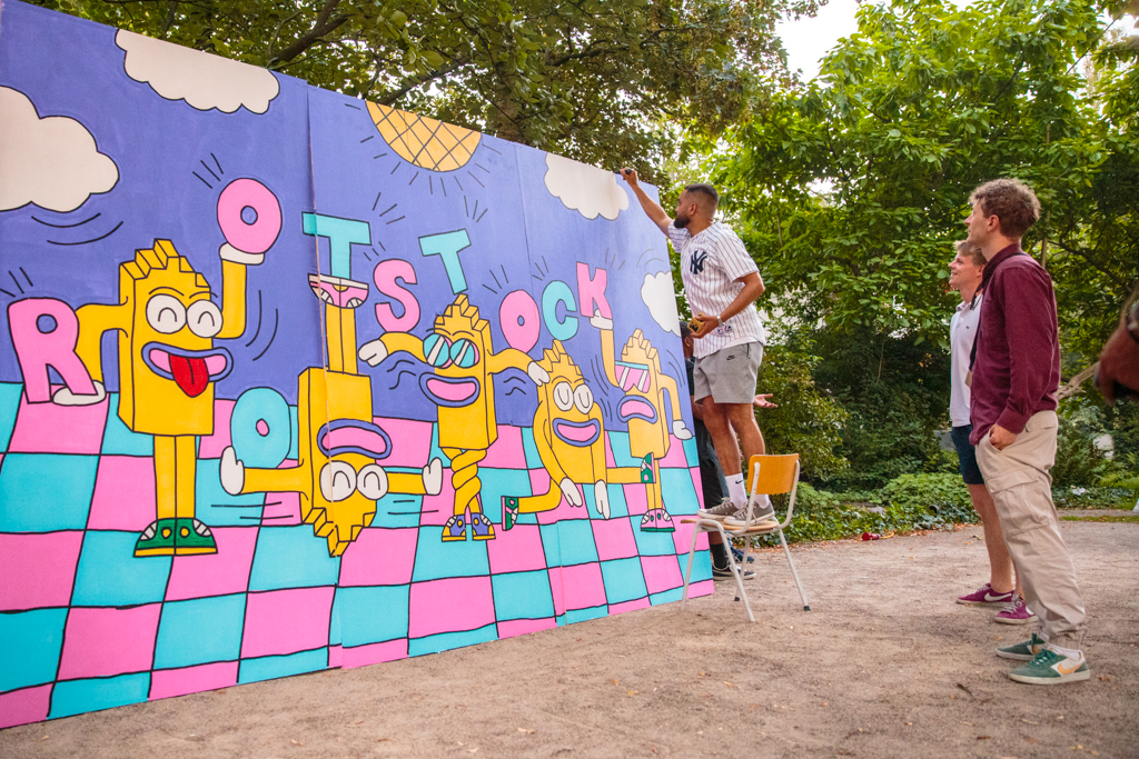 Foto van Dynamic Arts kunstenaar Snars die een groot kunstwerk maakt tijdens het Rootstock dans event van Dynamic Arts, Solid Ground Movement en de Tolhuistuin in Amsterdam