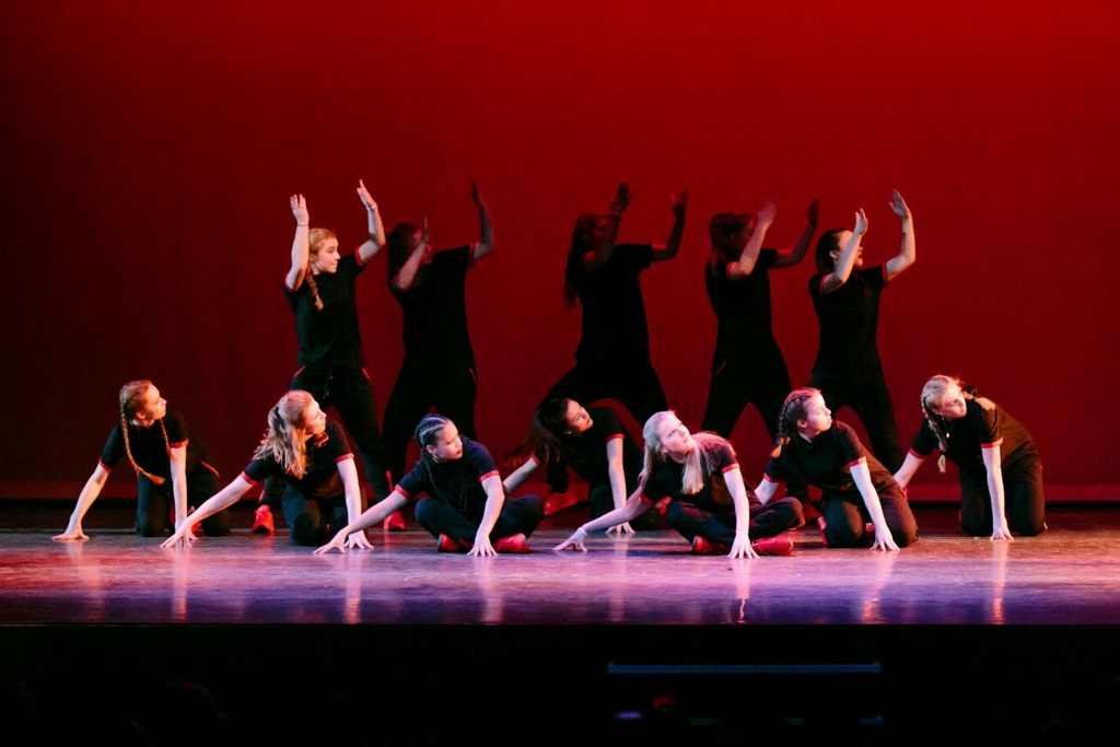 Dansvoorstelling van Dynamic Arts Dance Academy met jongeren in een dans pose in het Singer Laren