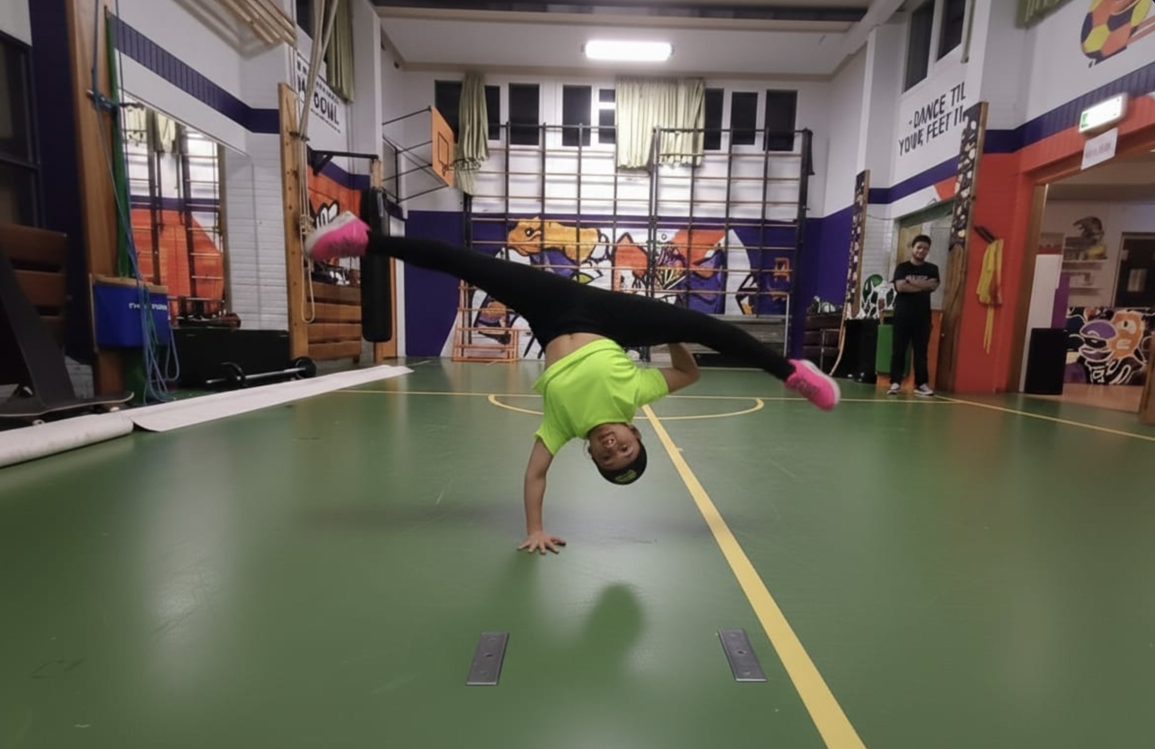 Foto van een Bgirl die op 1 hand staan in de zaal van Dynamic Arts in Laren