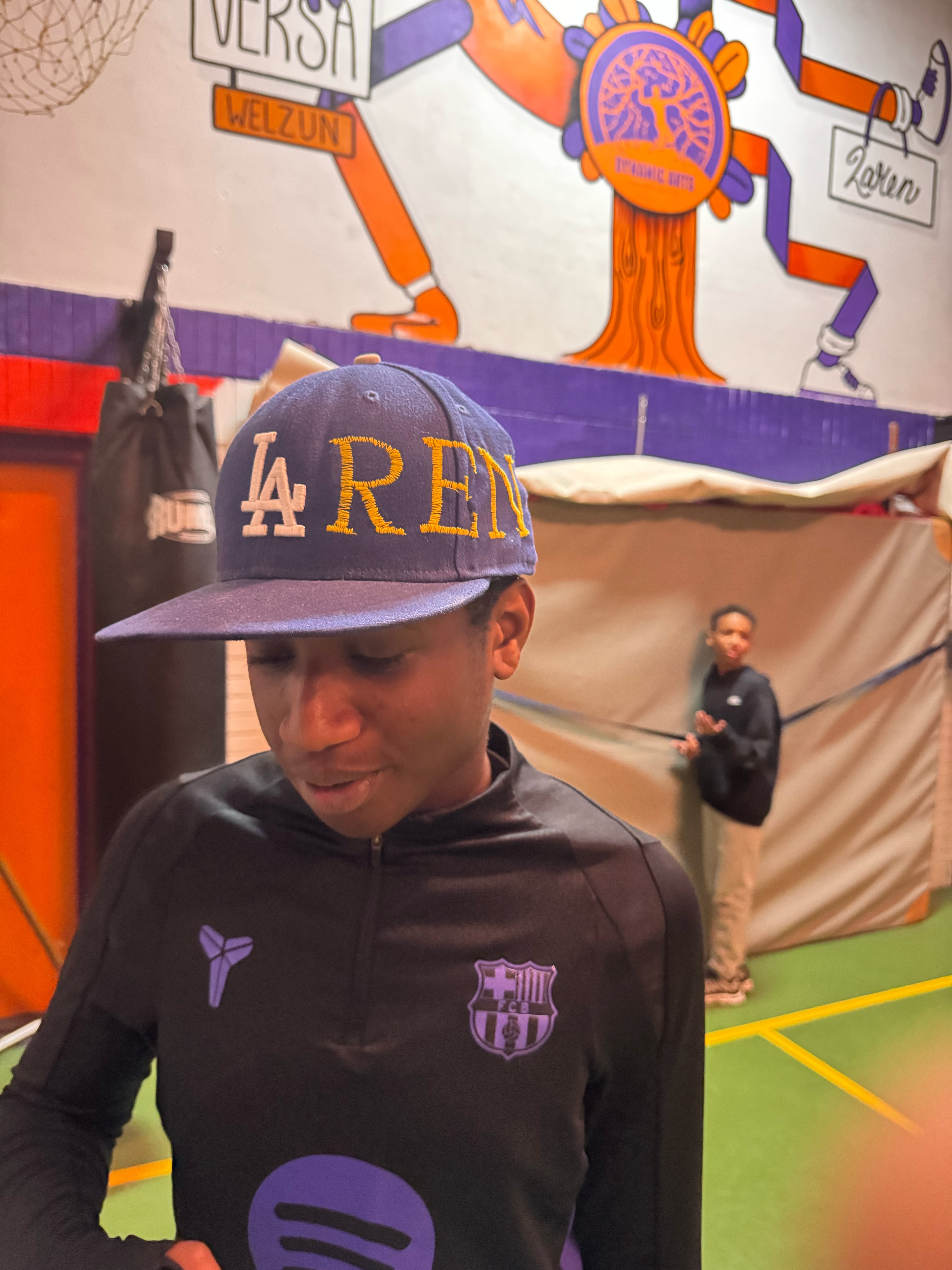 Jongen bij Dynamic Arts Laren in de gymzaal naast een bokszak.