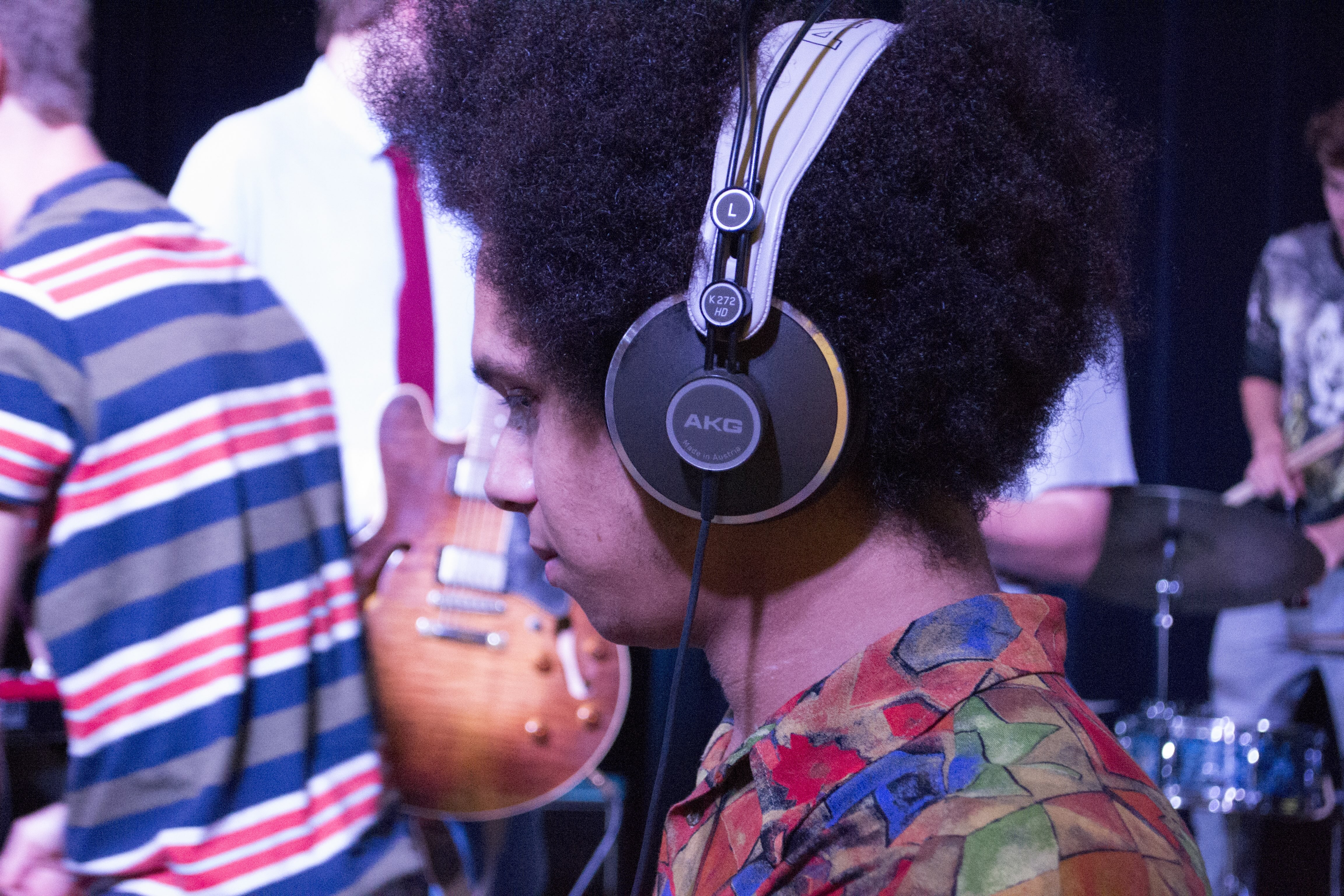 Jongen met mooie afro en een koptelefoon aan het dj'en.