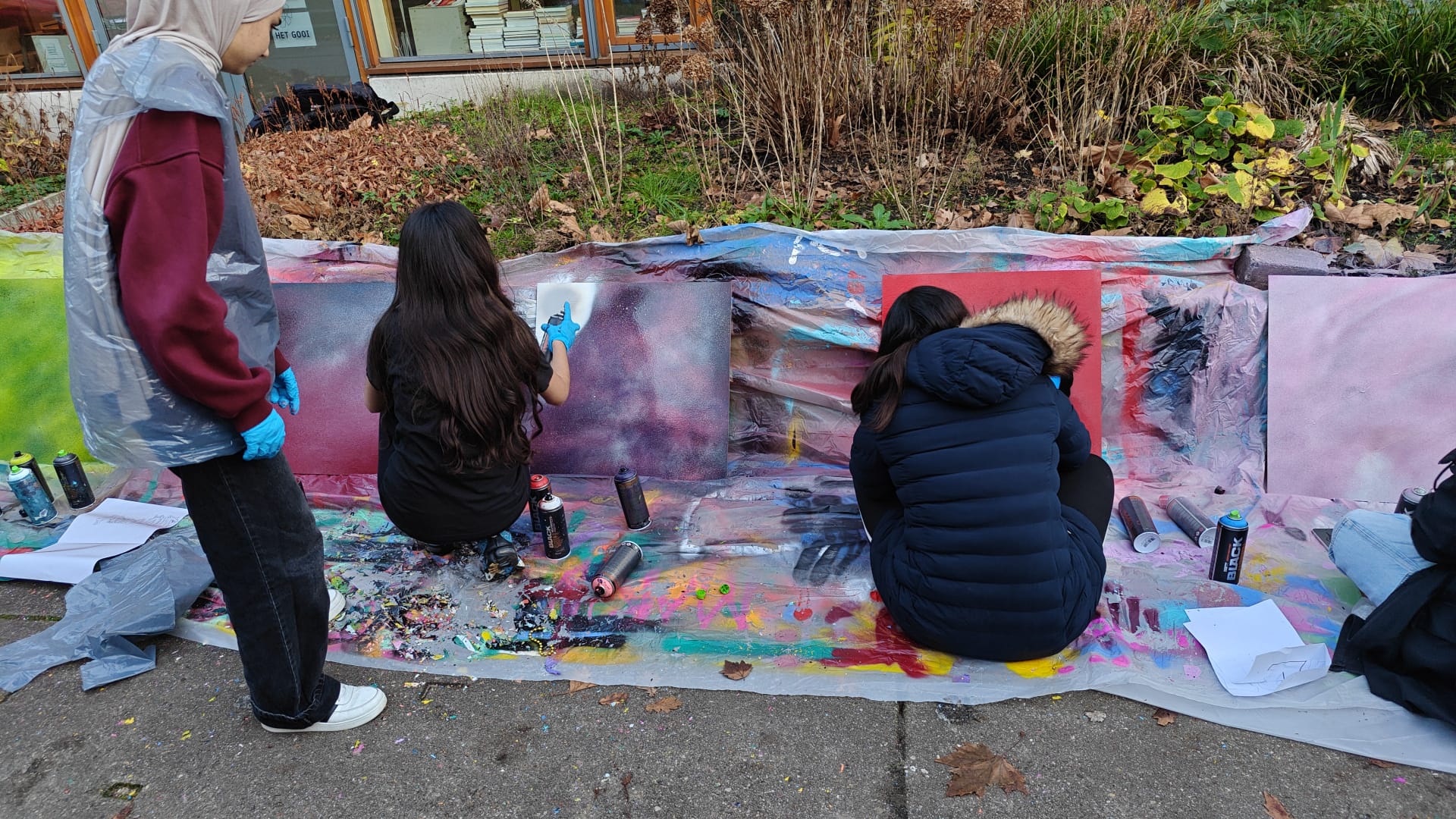 Meiden op een school die graffiti spuiten